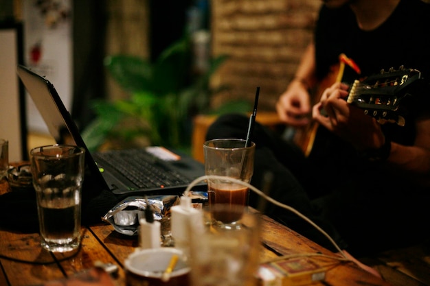 Sección media de una persona tocando la guitarra en un café