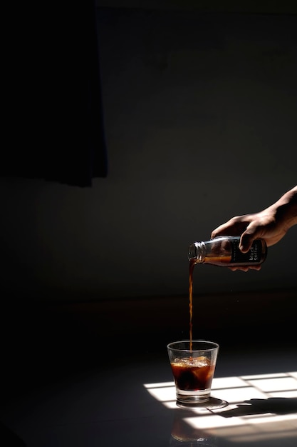 Sección media de una persona vertiendo vino en un vaso