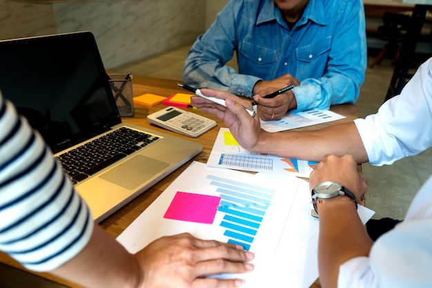 Foto sección media de personas de negocios discutiendo papeleo en el escritorio