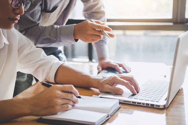 Sección media de personas de negocios que trabajan en la computadora portátil en la oficina