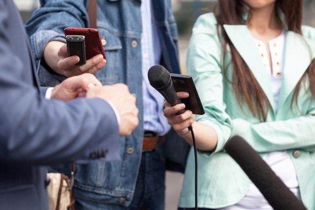 Sección media de personas con teléfonos móviles y micrófono