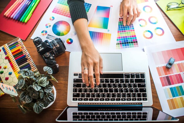 Sección media de un profesional de diseño trabajando en muestras de color en la oficina