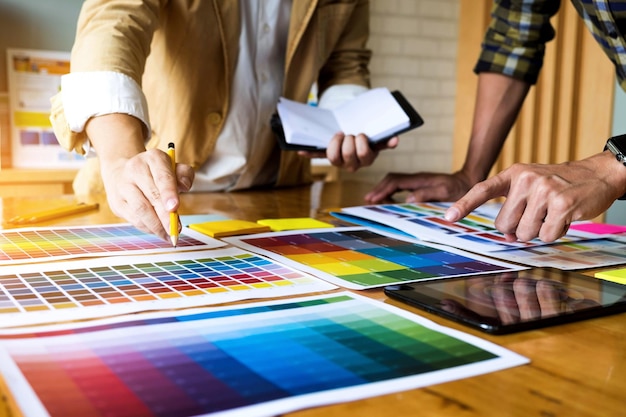 Sección media de profesionales del diseño trabajando en una muestra de color en la mesa