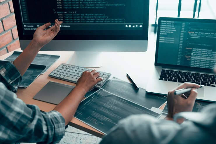 Foto sección media de programadores de computadoras discutiendo en el escritorio de la oficina