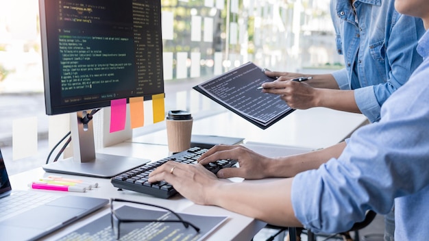 Foto sección media de programadores de computadoras que utilizan la computadora en el escritorio de la oficina