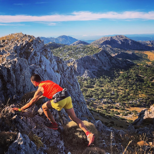 Foto sección media de la roca del hombre en la montaña contra el cielo