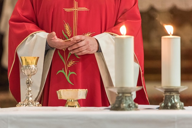 Sección media del sacerdote orando en la mesa de la iglesia
