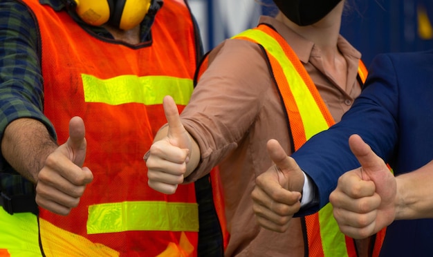 Foto sección media de los trabajadores que muestran el dedo pulgar hacia arriba