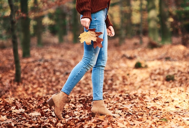 Bajo la sección de mujer caminando en el bosque de otoño