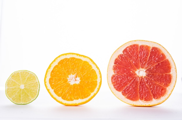 Foto sección de pomelo, naranja y lima sobre un fondo blanco, aislar. el concepto de vitaminas, frescura, naturalidad. foto de alta calidad