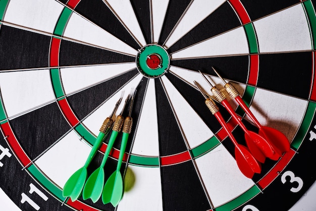 Sechs Darts liegen auf einer Dartscheibe