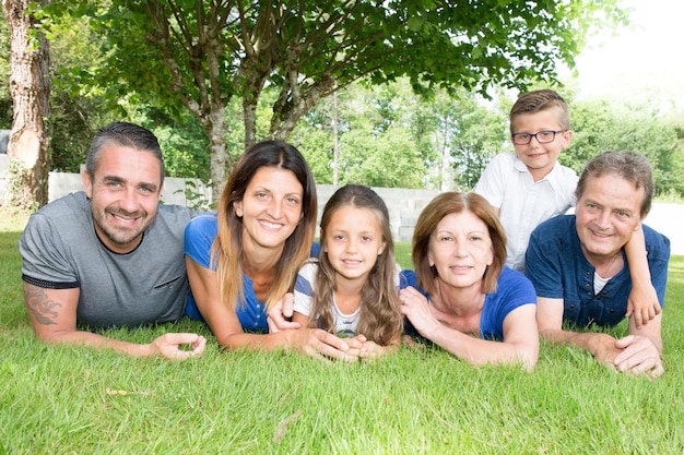 Sechsköpfige Familie 6, die glücklich und fröhlich auf dem Gras liegen