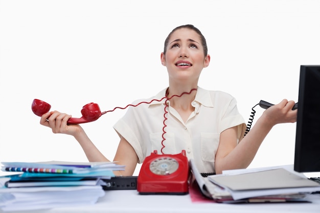 Foto secretaria estresada contestando los teléfonos