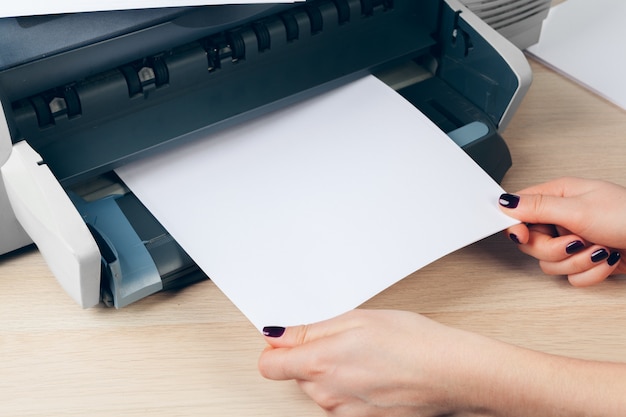 Secretaria femenina haciendo fotocopias en la máquina xerox en la oficina