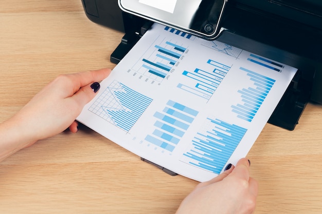 Secretaria femenina haciendo fotocopias en la máquina xerox en la oficina