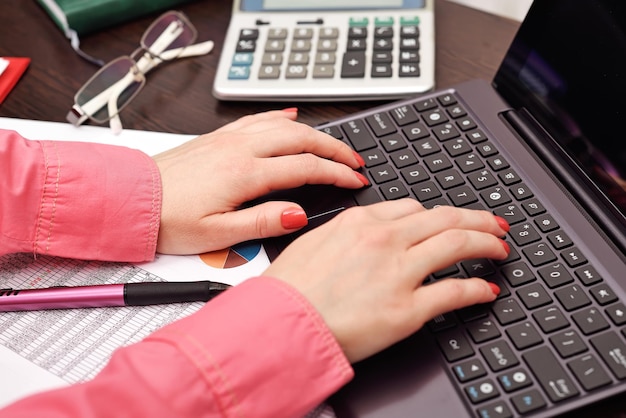 Secretaria presionando los botones de la computadora portátil