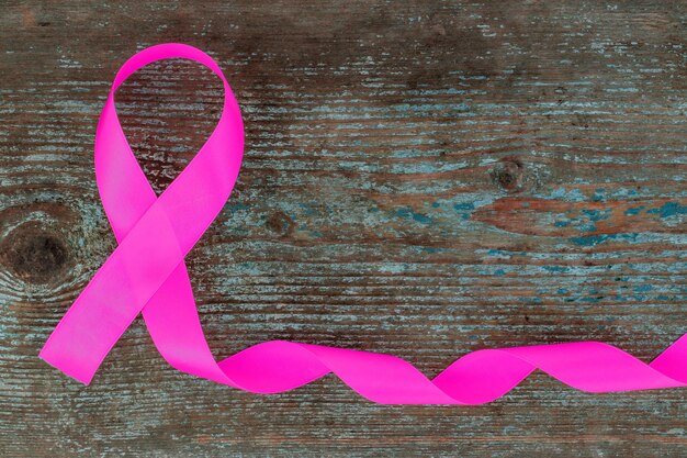 Seda rosa - símbolo de concienciación sobre el cáncer de mama en la madera