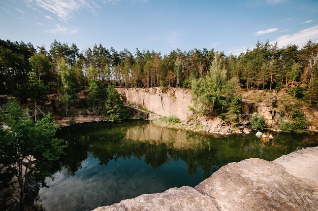 See auf dem Hintergrund von Felsen und Tannen