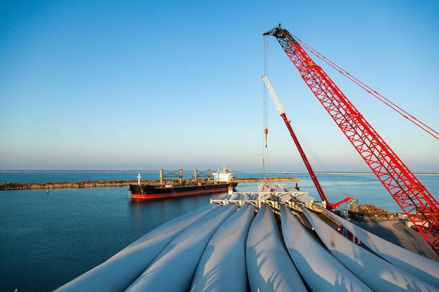 Seehafen Verladung der Rotorblätter von Windkraftanlagen im Seehafen mit zwei Kränen auf ein Frachtschiff