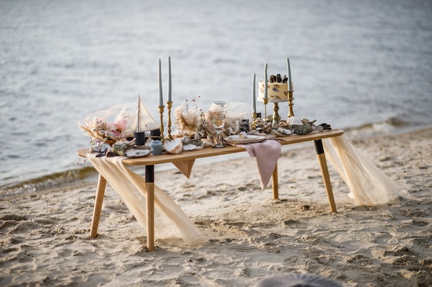 Seehochzeitsdekor an der Küste. Hochzeitstorte und Blumen bei der Veranstaltung.