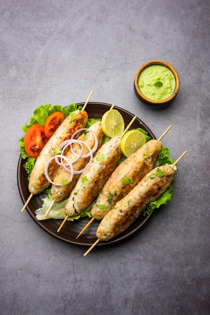 Seekh Kabab feito com frango picado ou keema de carneiro, servido com chutney verde e salada