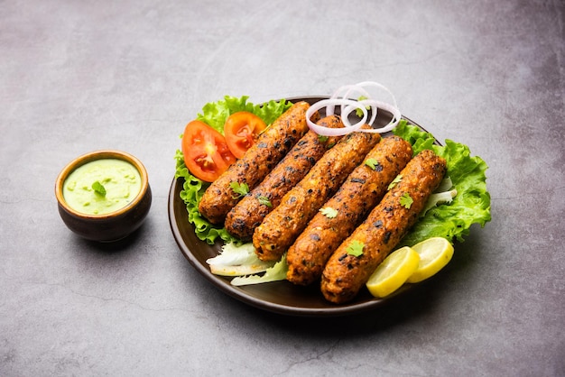 Seekh Kabab feito com frango picado ou keema de carneiro, servido com chutney verde e salada