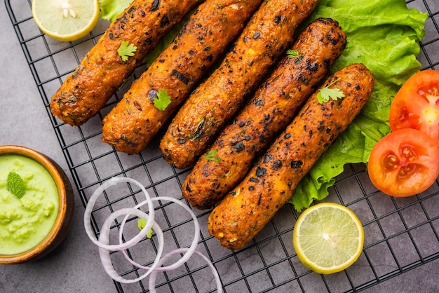 Seekh Kabab feito com frango picado ou keema de carneiro, servido com chutney verde e salada