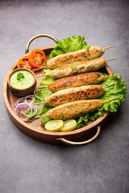 Seekh Kabab feito com frango picado ou keema de carneiro, servido com chutney verde e salada