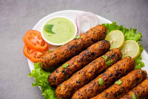 Seekh kabab feito com frango picado ou keema de carneiro, servido com chutney verde e salada