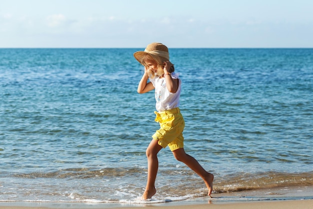 Seekinder Urlaub Kleines Mädchen, das am Meeresstrand läuft und Wellen spielt Sommerurlaub am Meer