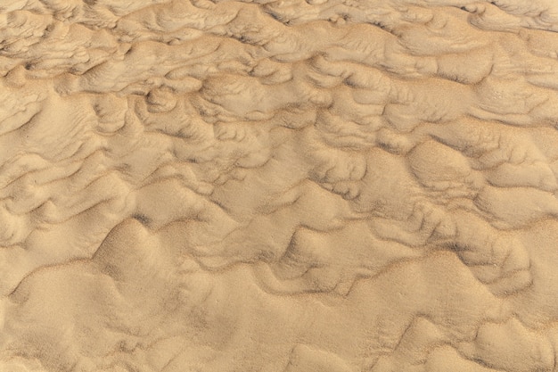 Seesand.Detail des beige sandigen Strandhintergrundes, Muster auf dem Seesand.