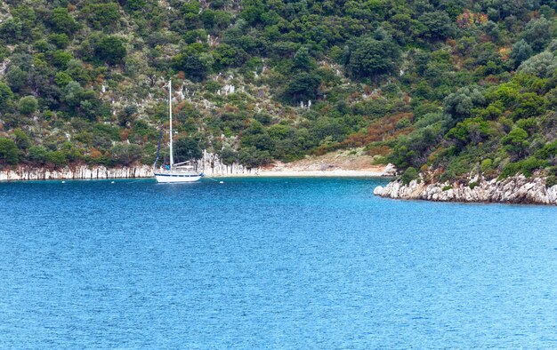 Seesommerküstenansicht mit Yacht nahe kleinem Strand Griechenland