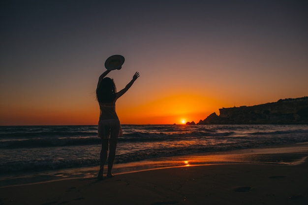 Seestrandmädchenschattenbild, Sonnenuntergang