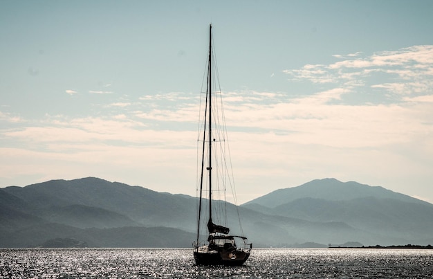Segelboot auf See gegen Berge