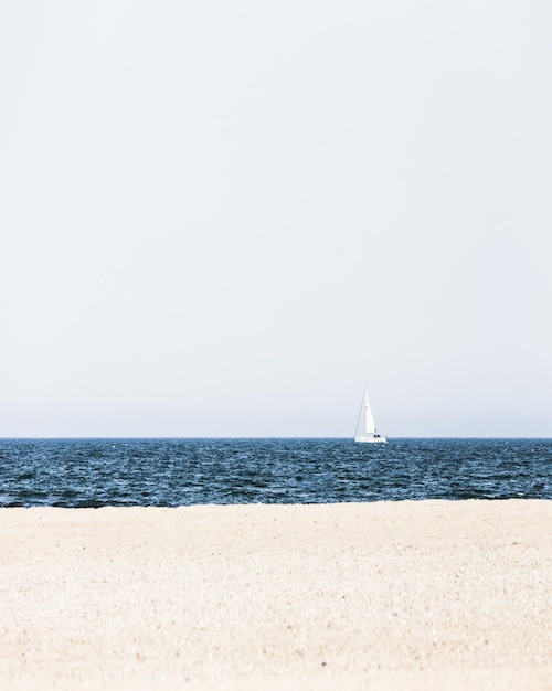 Segelboot fährt auf dem Meer gegen klaren Himmel.