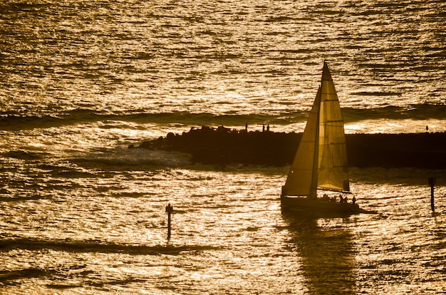 Segelboot ging bei Sonnenuntergang mit Magic Island, Oahu, Hawaii im Hintergrund voran