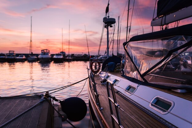 Segelboot mit Holzdeck, das im Marine bei schönem Sonnenuntergang steht