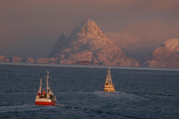 Foto segelboot segelt auf dem meer gegen den orangefarbenen himmel