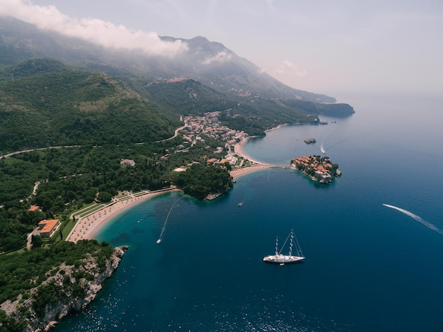 Segelboot segelt entlang der Bucht zur königlichen Strandvilla Milocer montenegro