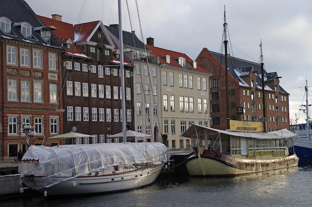 Segelboote, die am Fluss an Gebäuden gegen den Himmel festgemacht sind