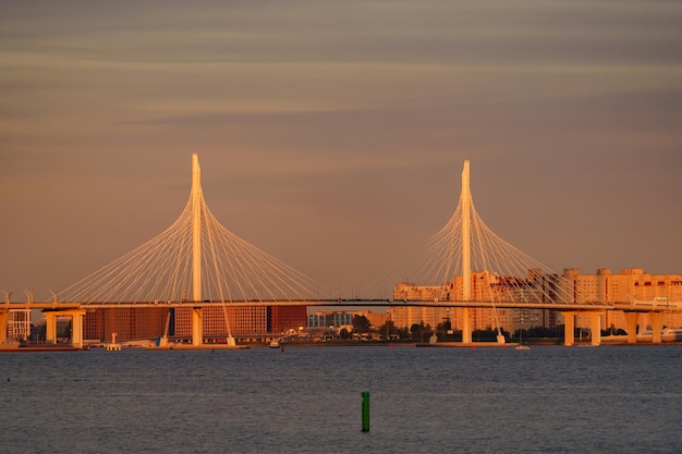 Segelboote im Hintergrund der neuen Schrägseilbrücke im Sonnenuntergang