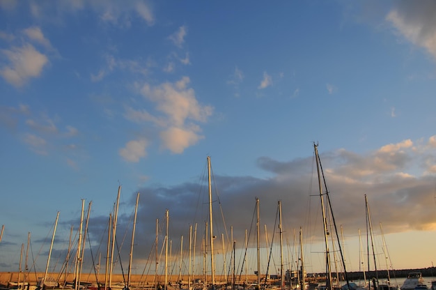 Segelbootmasten im Hafen mit Sonnenunterganghintergrund.