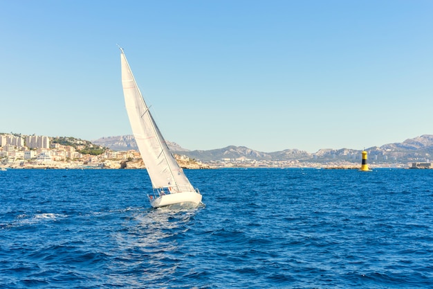 Segeln im Wind durch die Wellen am Meer