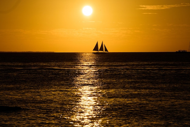 Segeln mit einem wunderschönen Sonnenuntergang im Ozeanhintergrund