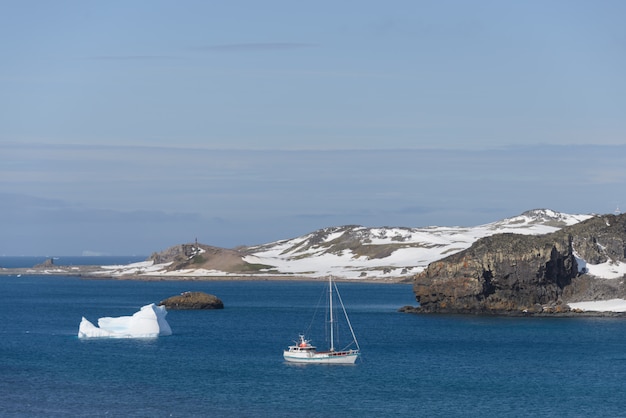 Segelyacht und Eisberg im antarktischen Meer