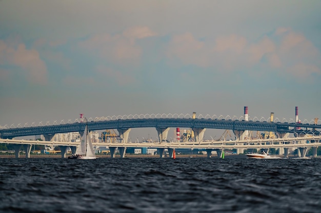 Segelyachten auf dem Hintergrund der Autobahn Bulk Island Baukräne Rohre der Wärmekraft