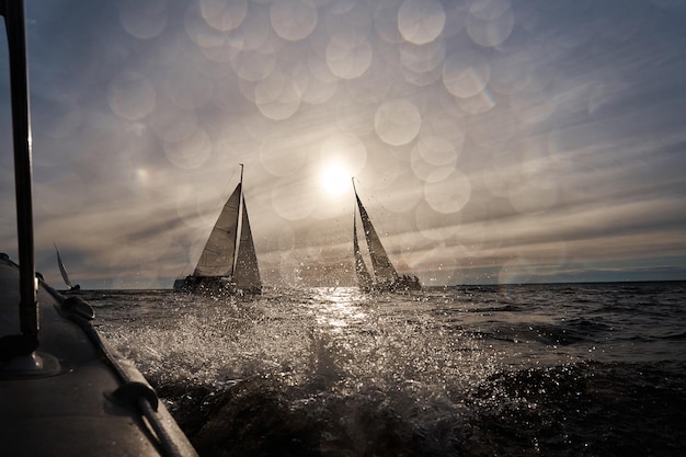 Segelyachten in Regatta bei Sonnenuntergang Segelregatta heiße Verfolgungsspritzer Wasser der klare Himmel