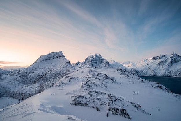 Segla-Berg auf schneebedecktem Hügel mit buntem Himmel im Sonnenaufgang auf Senja-Insel