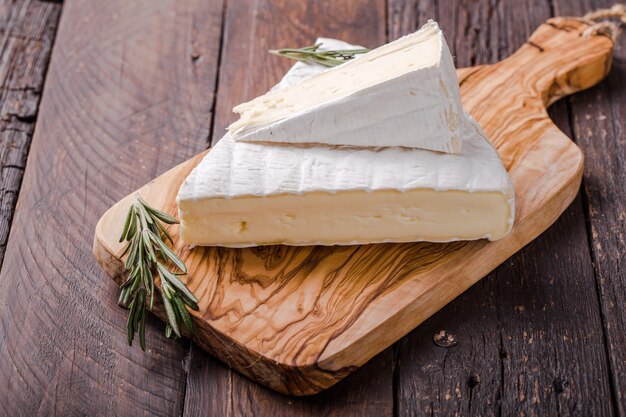 Segmento de queso camembert sobre tabla de madera