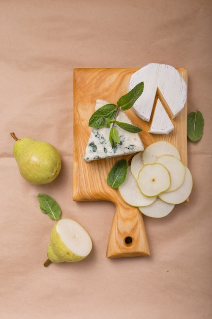 Segmento de queso moho azul - Gorgonzola con pera y nueces sobre papel.